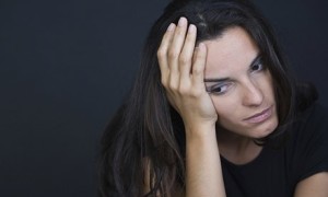 Young depressed woman on black background